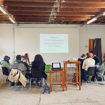 Een groep studenten van de docentenopleiding beeldendekunst en vormgeving uit Tilburg zit klaar om een presentatie te krijgen in de Stadsgalerij bij Witte Rook in Breda.